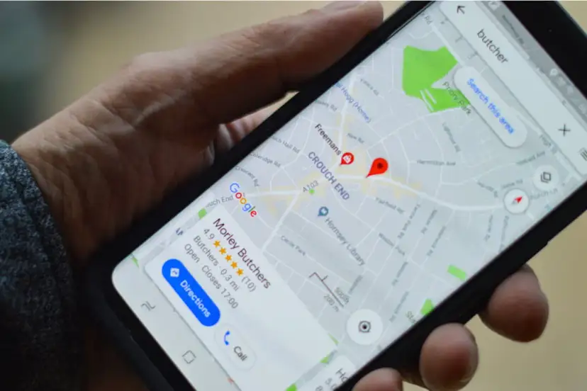 Dłoń trzyma smartfon z mapą Google, na której widoczny jest czerwony pinezka i nazwa "Morley Butchers".