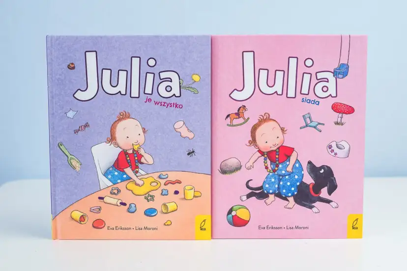 Skandynawskie książki dla dzieci "Julia je wszystko" i "Julia siada" z uroczymi ilustracjami.