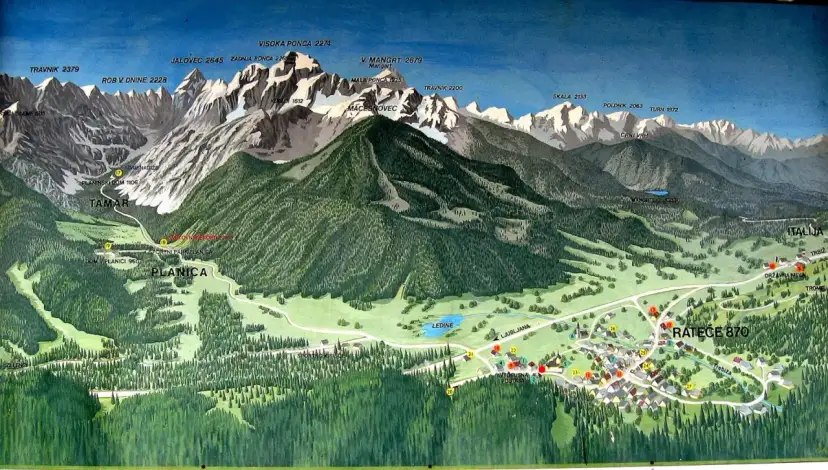 Planica, znana zmagovalnih skakalnic, je obdana z veličastnimi gorami, kot so Mangart, Jalovec in Visoka Ponca.