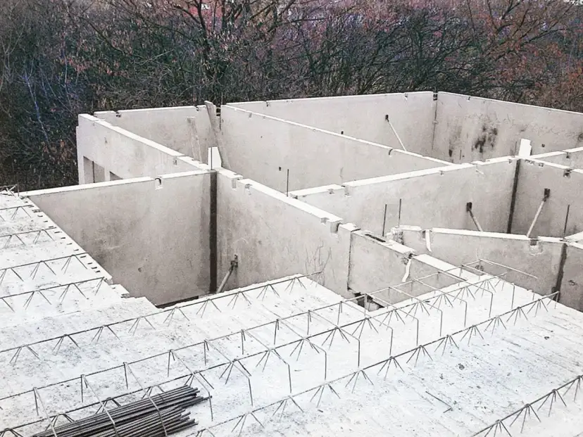 Budowa stropu filigran: betonowe elementy i zbrojenie na placu budowy.