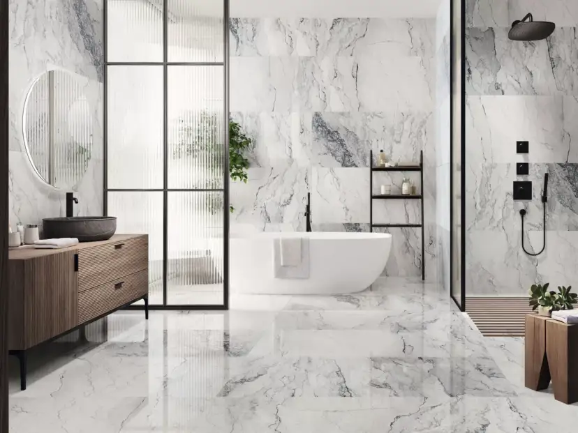 Elegantes combinaciones de azulejos para baños con efecto mármol, bañera exenta y mueble de madera.