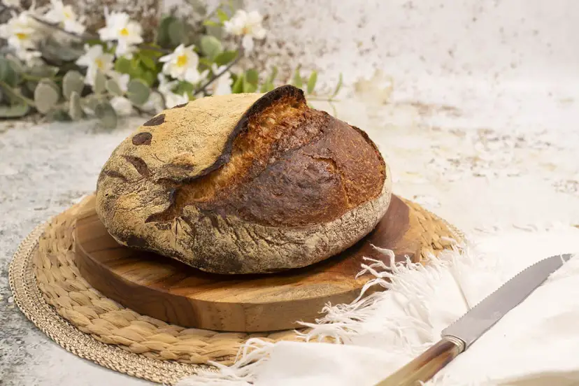 Pan artesanal de masa madre, dorado y crujiente, listo para disfrutar. El arte de hacer pan con masa madre.