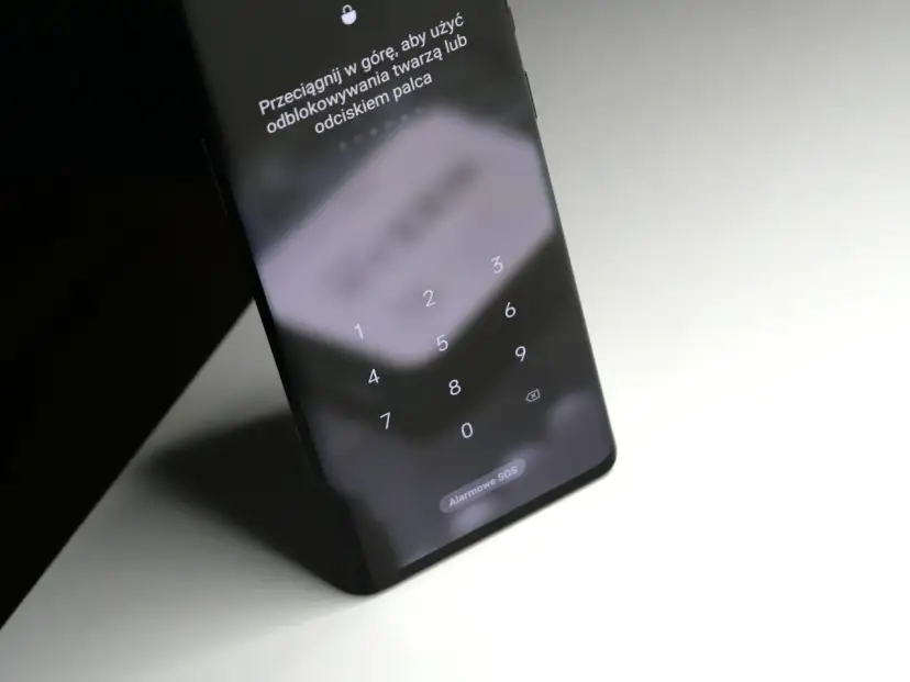 Ekran blokady telefonu z klawiaturą numeryczną i instrukcją, jak odblokować telefon przez aparat (rozpoznawanie twarzy) lub odcisk palca.