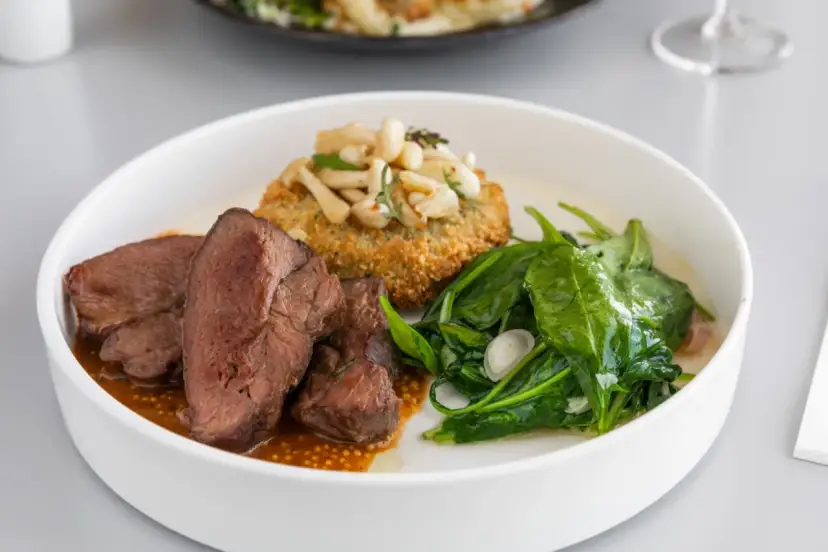 Krojone mięso wołowe z sosem, panierowany kotlet z grzybami i szpinak.