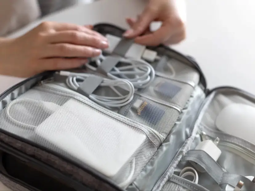 Pakowanie elektroniki do podróży. Czy powerbanki o dużej pojemności można przewozić w samolocie? W torbie znajdują się kable, ładowarki i powerbanki.