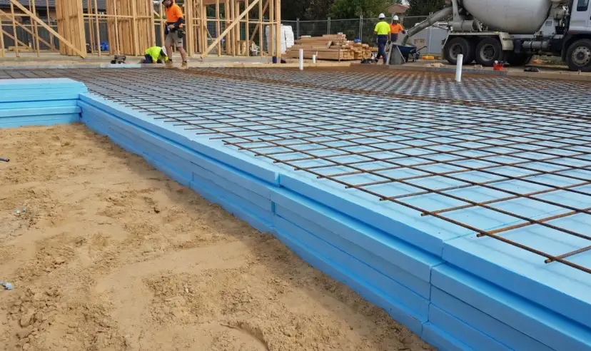 Niebieski styrodur ułożony na piasku, zbrojenie na wierzchu, budowa fundamentów.