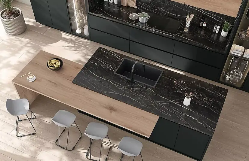 Nowoczesna kuchnia z czarnym blatem marmurowym, zlewem i wyspą.