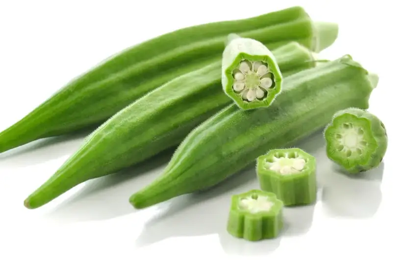 Kilka zielonych strąków okry, w tym przekrojone, ukazujące nasiona. Okra po polsku to pyszny dodatek do dań.