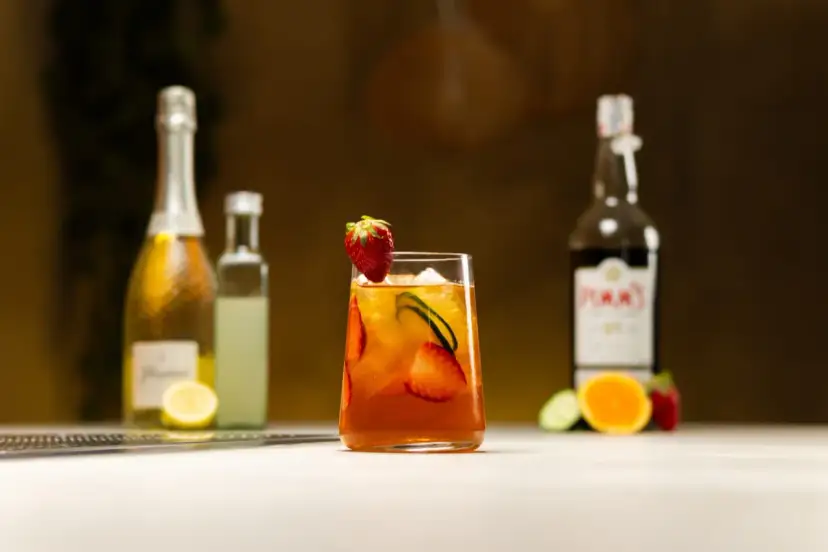 Orzeźwiający drink z Pimm's No. 1, truskawkami i ogórkiem, w kontraście do Aperol Spritz.