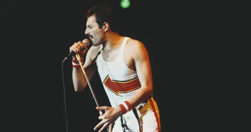 Freddie Mercury, jeden z najlepsi muzycy wszechczasów, śpiewa do mikrofonu na koncercie.