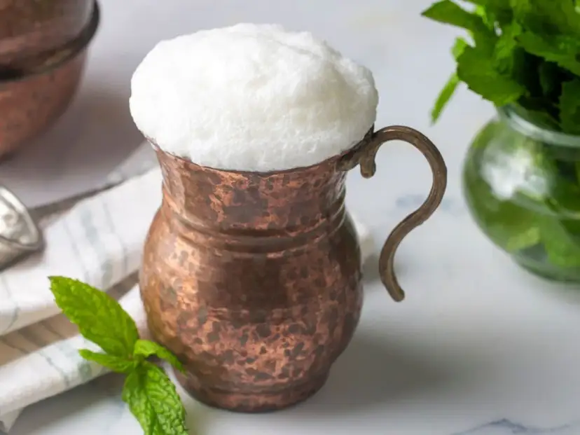Puszysty ayran w miedzianym kubku, orzeźwiający napój, który idealnie gasi pragnienie. Poczuj, jak smakuje ayran!