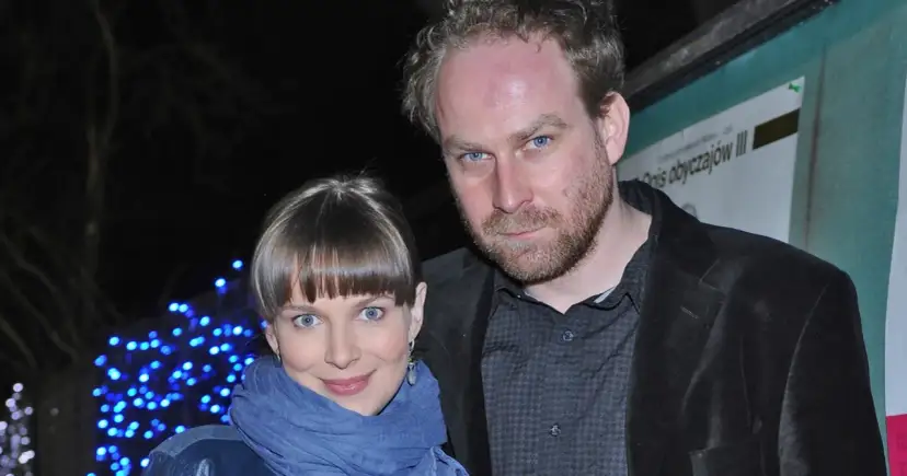 Marcin Perchuć i jego partnerka, uśmiechnięci na tle niebieskich światełek.