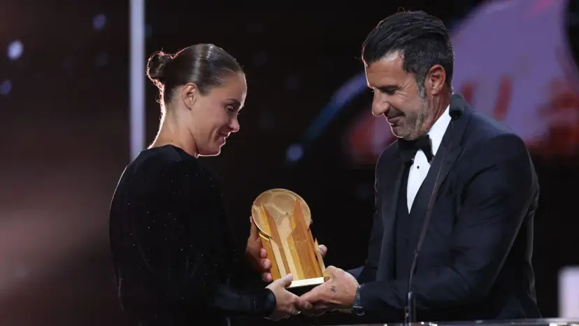 Piłkarz Luis Figo wręcza Złotą Piłkę kobiecie.
