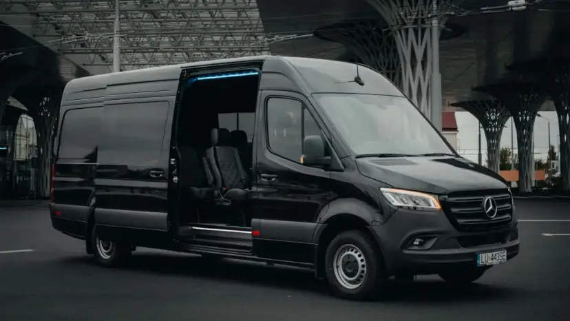 Czarny Mercedes Sprinter z otwartymi drzwiami, wnętrze z wygodnymi fotelami. Zastanawiasz się, ile kosztuje bus do Francji?