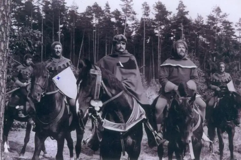 Scena z filmu, gdzie kręcono bitwę pod Grunwaldem. Rycerze na koniach w lesie, przygotowani do walki.