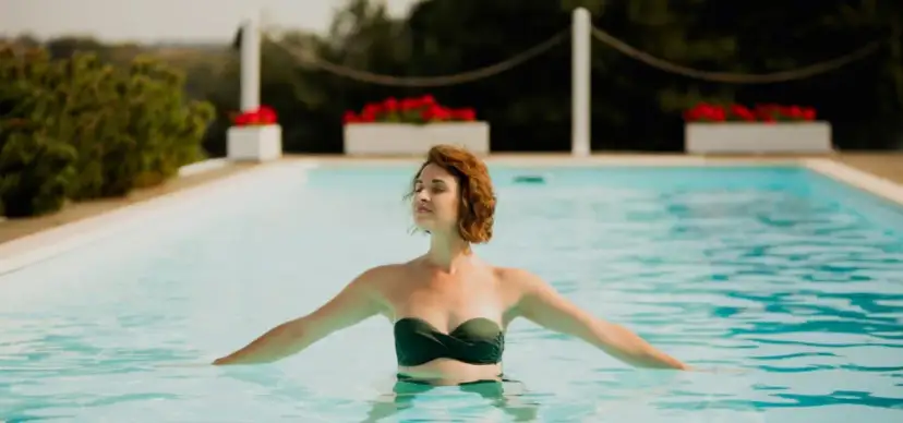 Kobieta zamyka oczy, ciesząc się relaksem w basenie. Idealny weekend w spa dla par.