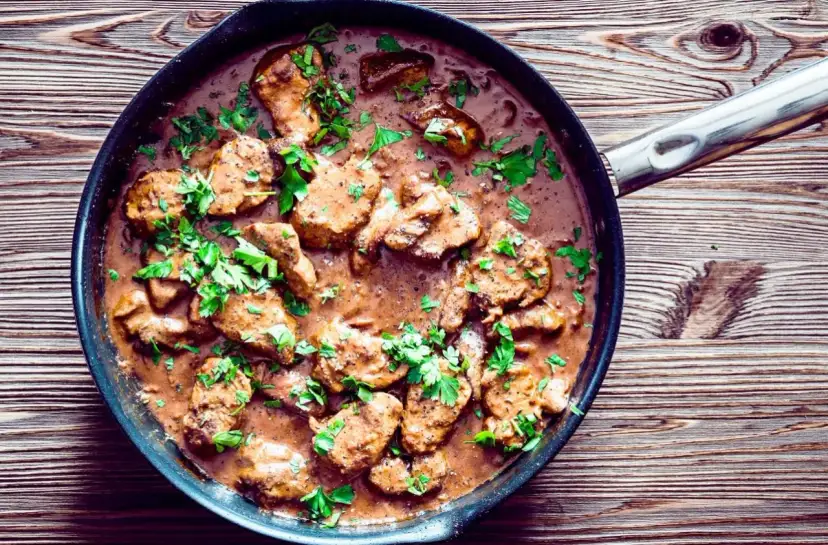 Polędwica wieprzowa w sosie, posypana natką pietruszki. Pyszne danie, które warto znać, jeśli interesuje Cię polędwica wieprzowa kcal.