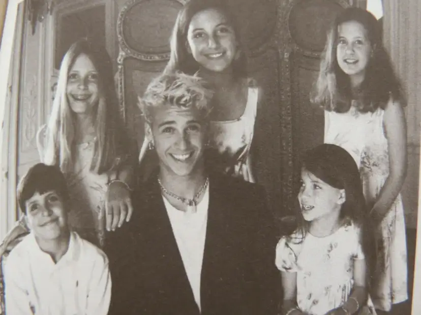 Uśmiechnięta grupa dzieci, być może danielle steel dzieci, pozuje do zdjęcia w eleganckim wnętrzu.