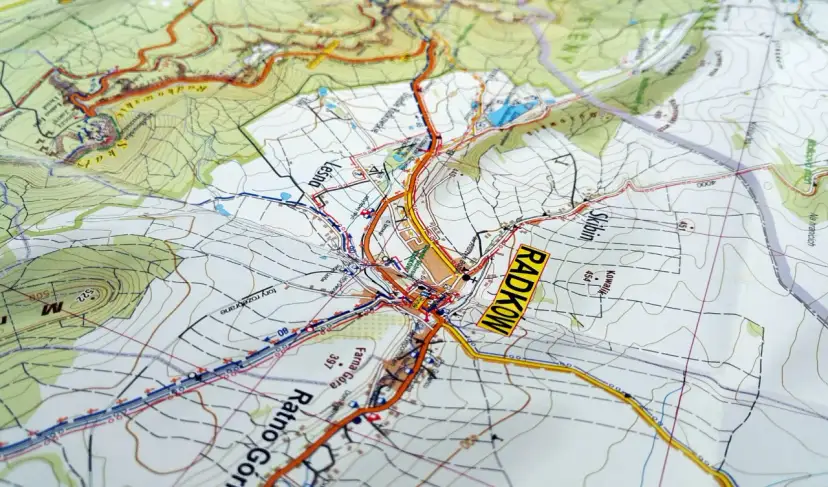 Mapa turystyczna z zaznaczonymi szlakami i miejscowościami, w tym Radkowem. Widoczne są **góry stołowe** i ukształtowanie terenu.