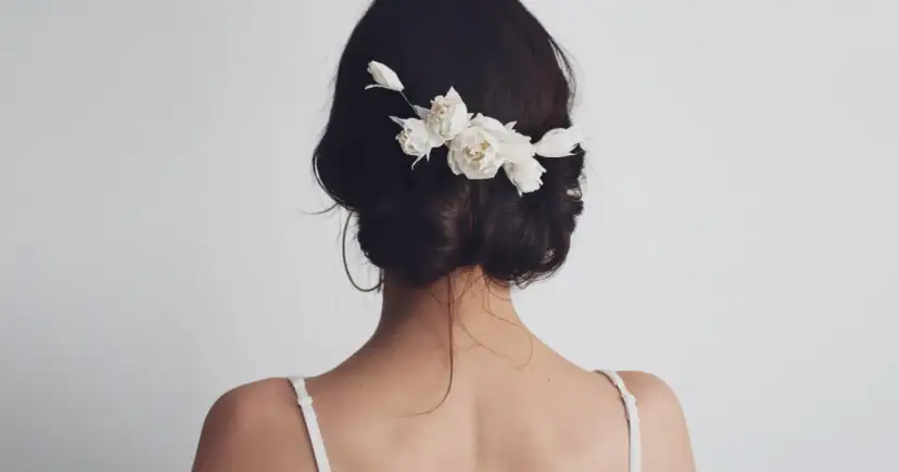 Delikatne kwiaty we włosach na ślub, dodające uroku ślubnej fryzurze.