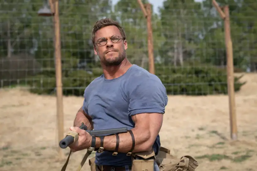 Mężczyzna w okularach i niebieskiej koszulce, uzbrojony, wygląda jakby właśnie wyszedł z Ministerstwa Niebezpiecznych Drani.