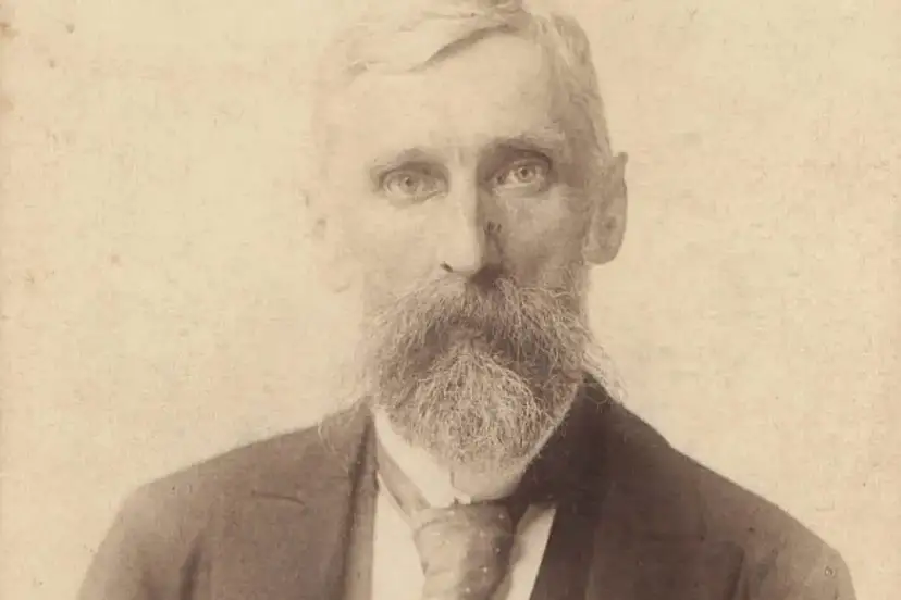 Portret starszego mężczyzny z bujną brodą i wąsami, ubranego w garnitur i krawat. Adam Asnyk do młodych.