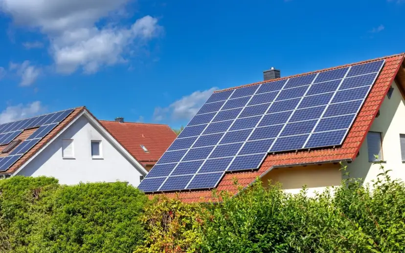 Domy z panelami fotowoltaicznymi na dachach. Zastanawiasz się, ile waży panel fotowoltaiczny? To zależy od jego wielkości i materiałów.