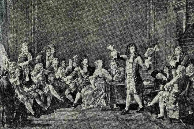 Grupa ludzi w strojach z epoki baroku, jeden mężczyzna przemawia, trzymając książkę.