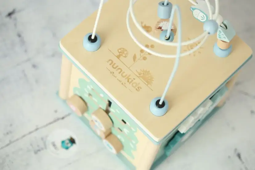 Drewniana kostka edukacyjna z labiryntem koralików i uroczymi leśnymi motywami. Idealna zabawka dla maluchów.