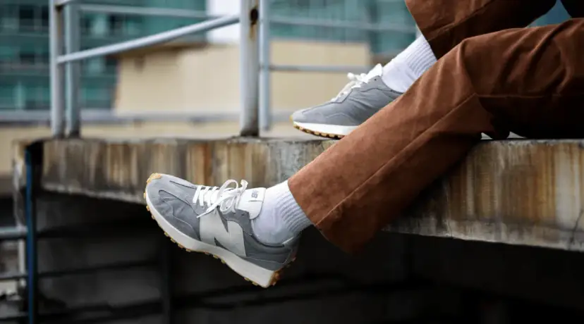 Szare New Balance na nogach w brązowych sztruksach. Zastanawiasz się, czy new balance można prać w pralce? Te wyglądają na czyste!