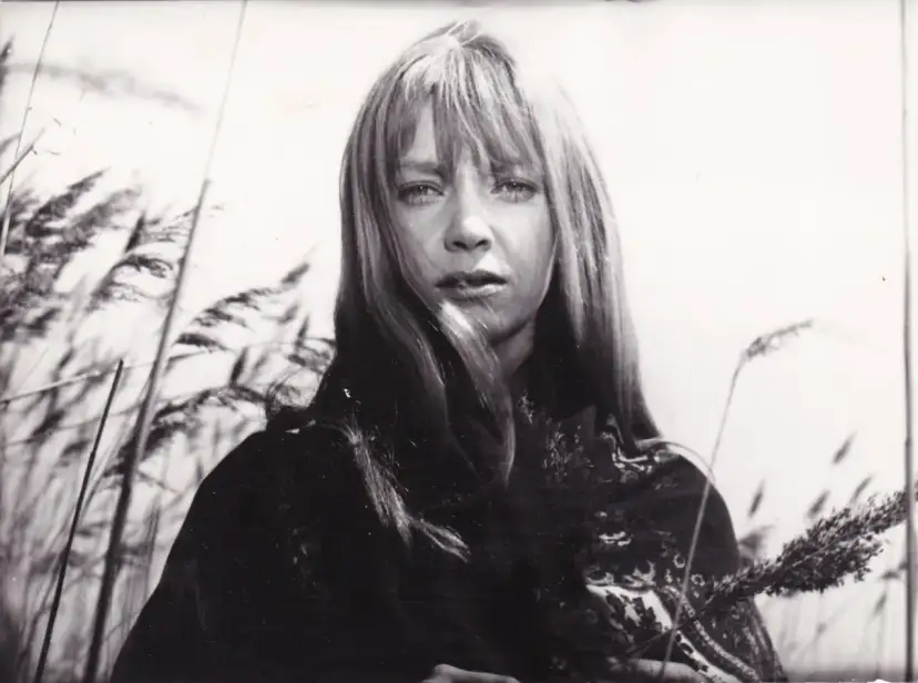 Irena Szczurowska w otoczeniu trzcin, zamyślona, z kosmykami włosów opadającymi na twarz.
