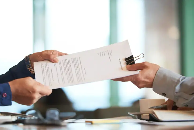 Dwie osoby przekazują sobie dokument "PARTNERSHIP AGREEMENT". To ważny moment, być może ustalanie co to dtr w umowie.