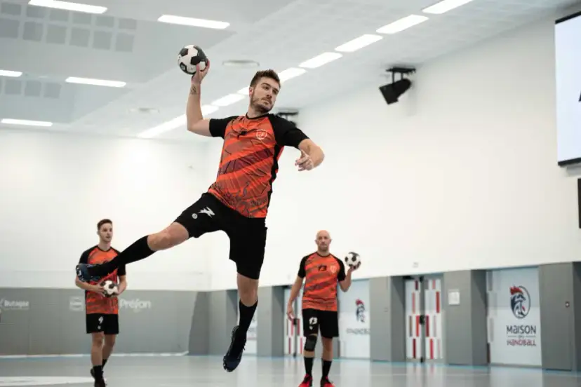 Gracz w skoku rzuca piłką ręczną. Kto wymyślił piłkę ręczną? Może ten zawodnik?