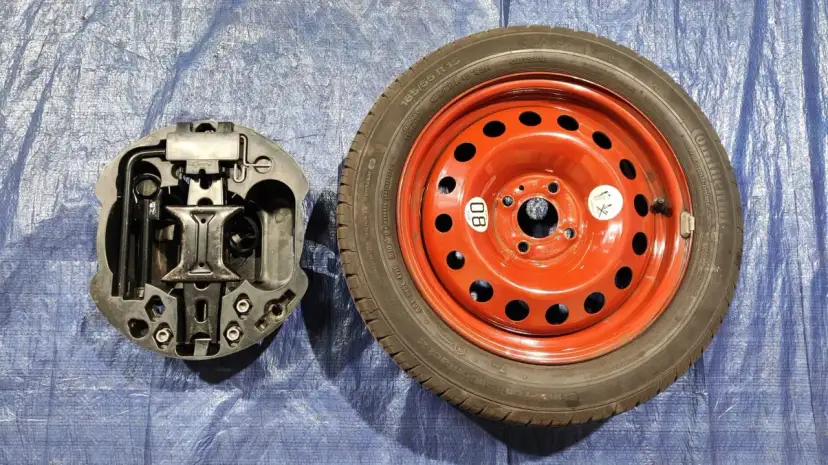 Koło zapasowe i schowek na klucze i podnośnik. Zestaw naprawczy do samochodu.