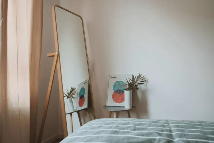 Lustro odbija plakat z kołami i wazon z suszonymi kwiatami. To inspiracja do stworzenia własnej konmari listy porządków.