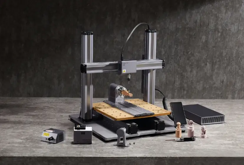 Drukarka 3D CNC z akcesoriami i wydrukowanymi figurkami.