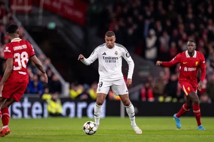Piłkarz Realu Madryt z numerem 9 drybluje, podczas gdy zawodnicy Liverpoolu próbują go zatrzymać. Czy to on poprowadzi swoją drużynę do zwycięstwa w Lidze Mistrzów?