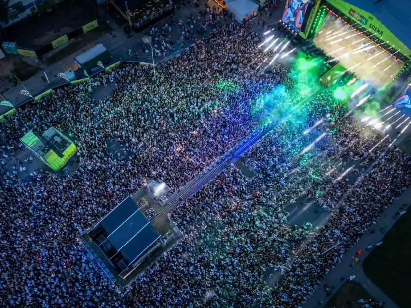 Tłum ludzi na koncercie podczas Łódź Summer Festival 2026. Kolorowe światła i dym tworzą niesamowitą atmosferę.