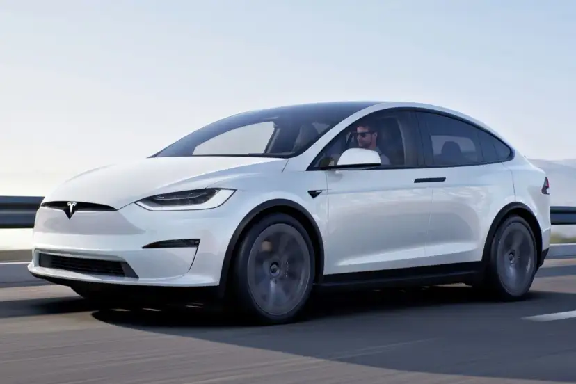 Biała Tesla Model X jedzie po drodze. Zastanawiasz się, ile kosztuje Tesla Model X?