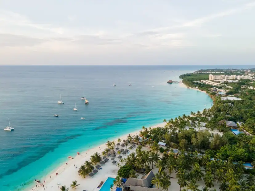 Rajska plaża na Zanzibarze z turkusową wodą, łodziami i luksusowymi hotelami. Sprawdź Zanzibar ceny i zaplanuj wymarzone wakacje!