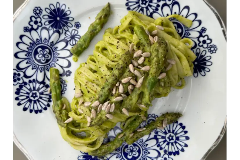 Makaron z zielonym pesto i szparagami, posypany pestkami słonecznika. Czy makaron jest zdrowy? Zależy od dodatków!
