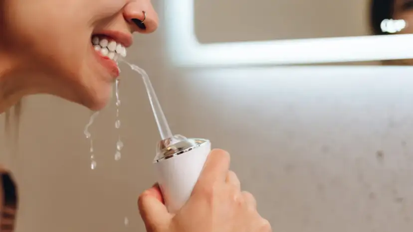 Kobieta używa irygatora. Zastanawiasz się, jaka woda do irygatora będzie najlepsza? Czysta woda to podstawa dla zdrowego uśmiechu.