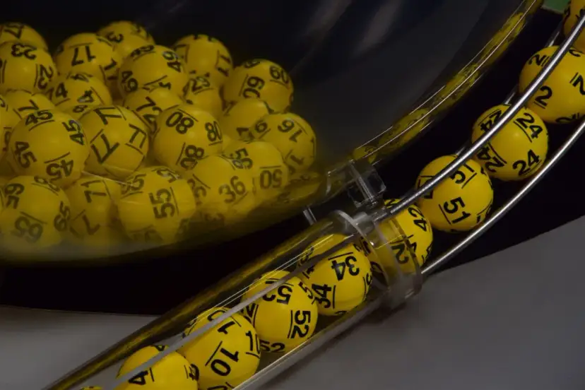Żółte kulki z numerami w maszynie losującej, które wyłonią zwycięzców gry Eurojackpot.