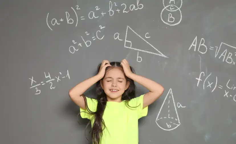 Dziewczynka z rękami wplątanymi we włosy, wyraźnie przeżywająca problemy z matematyką. Wokół niej wzory i figury geometryczne na tablicy.