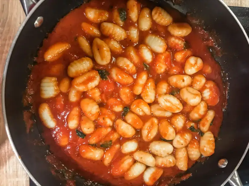 Pyszne gnocchi w aromatycznym sosie pomidorowym z ziołami, gotowe do podania. Idealny sos do gnocchi na szybki obiad.