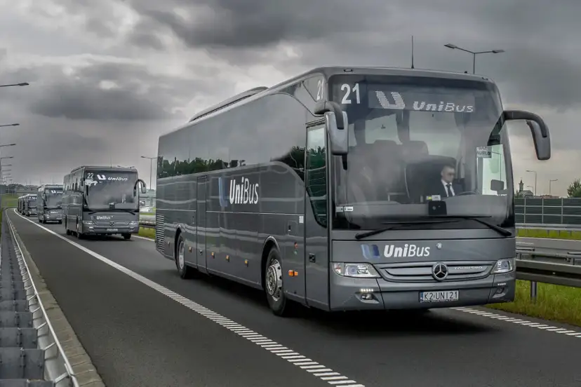 Szary bus UniBus z numerem 21 jedzie autostradą. To jeden z wielu pojazdów na trasie Kraków-Katowice.