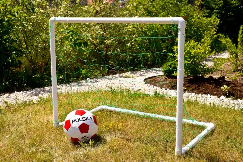 Bramka do piłki nożnej z rurek PCV i siatki, z piłką "Polska". Idealna do zabawy na trawie, pokazuje z czego zrobić bramkę do piłki nożnej.
