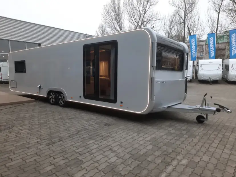 Nowy Adria Astella 904 HP, luksusowy caravan z panoramicznymi oknami i nowoczesnym designem, gotowy na podróże.