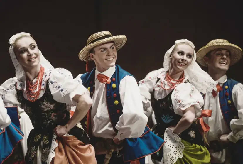 Tancerze w strojach ludowych, jakby Stanisław założył zespół Śląsk. Uśmiechnięci, w tradycyjnych strojach z haftami i koralami.