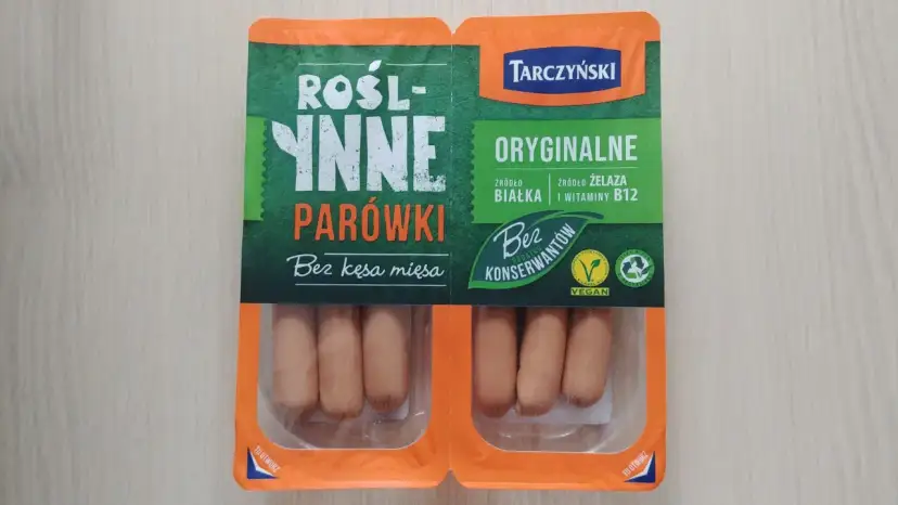 Opakowanie roślinnych parówek Tarczyński z widocznymi parówkami w środku.